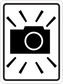 Road sign sticker with black camera icon and radiating warning lines inside a white border