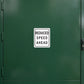 Road Sign Sticker applied in a smooth forest green single fleet workshop storage door, handle at far right edge