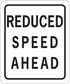 Road sign sticker with bold text: "REDUCED SPEED AHEAD"