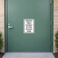 Road Sign Sticker applied in a smooth muted green school service entry door, handle far left and campus path far bottom