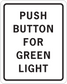 Road sign sticker with black border and text: PUSH BUTTON FOR GREEN LIGHT