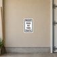 Road Sign Sticker applied in a continuous sandy beige private estate garage wall, garden rake far left edge