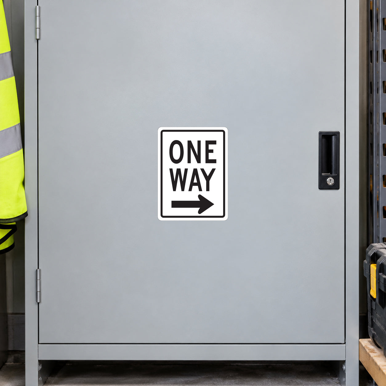 Road Sign Sticker applied in a smooth light grey single dispatch cupboard with safety vest and toolcase at extreme edges