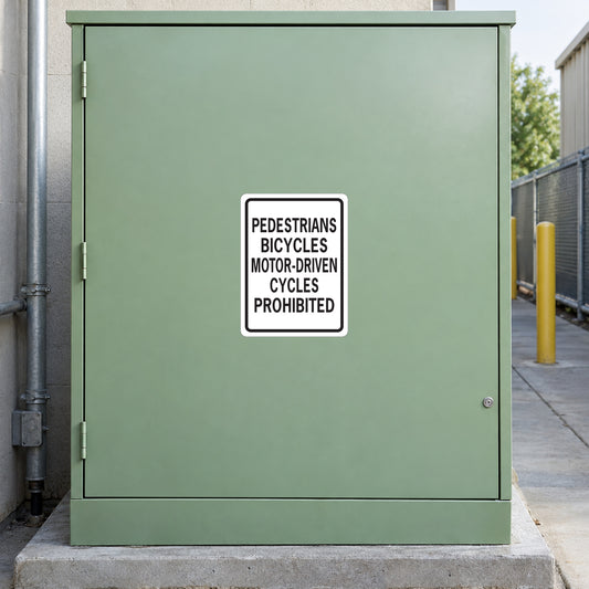 Road sign sticker: white box with black text 'PEDESTRIANS BICYCLES MOTOR-DRIVEN CYCLES PROHIBITED'