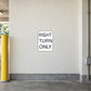 Road Sign Sticker applied in a continuous warm ivory parking access corridor wall with yellow bollard at far left