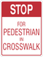 Road sign sticker with red STOP and text FOR PEDESTRIAN IN CROSSWALK