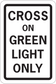 Road sign sticker with 'CROSS ON GREEN LIGHT ONLY' text, green background, white border.