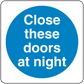 Safety sign sticker with blue circle and white text: Close these doors at night.