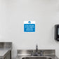 Safety Sign Sticker applied in a smooth white washable wall above a dedicated handwashing sink in a commercial food kitchen, sink and tap entirely below y85, soap dispenser far right and stainless bench extreme left