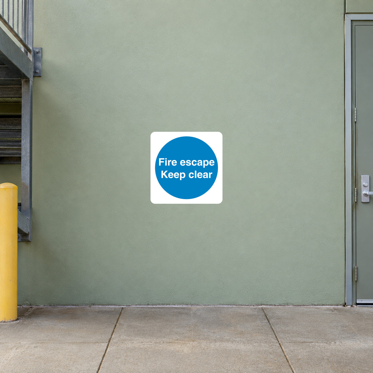 Safety sign sticker, white square with blue circle: 'Fire escape' 'Keep clear'.