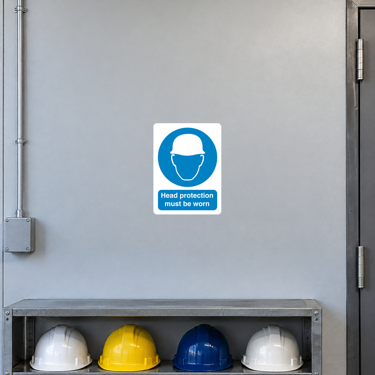 Safety sign sticker with blue head protection icon and text: Head protection must be worn