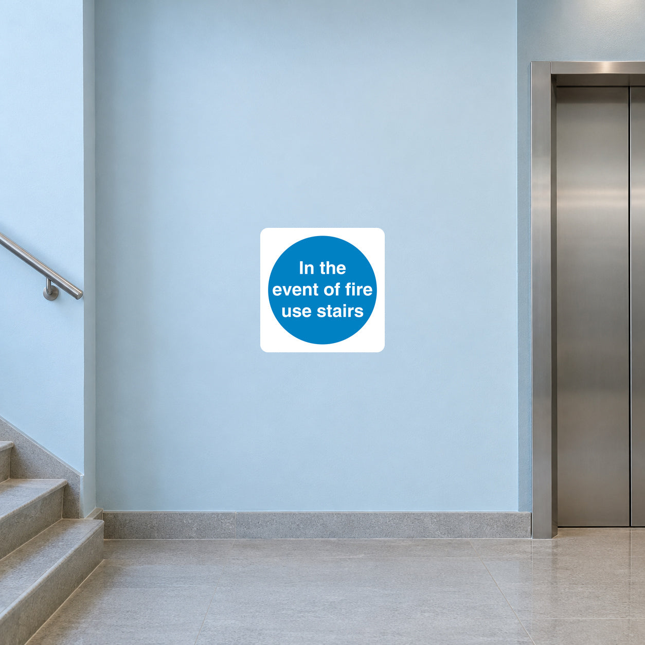 Safety sign sticker, white square with blue circle: 'In the event of fire use stairs'