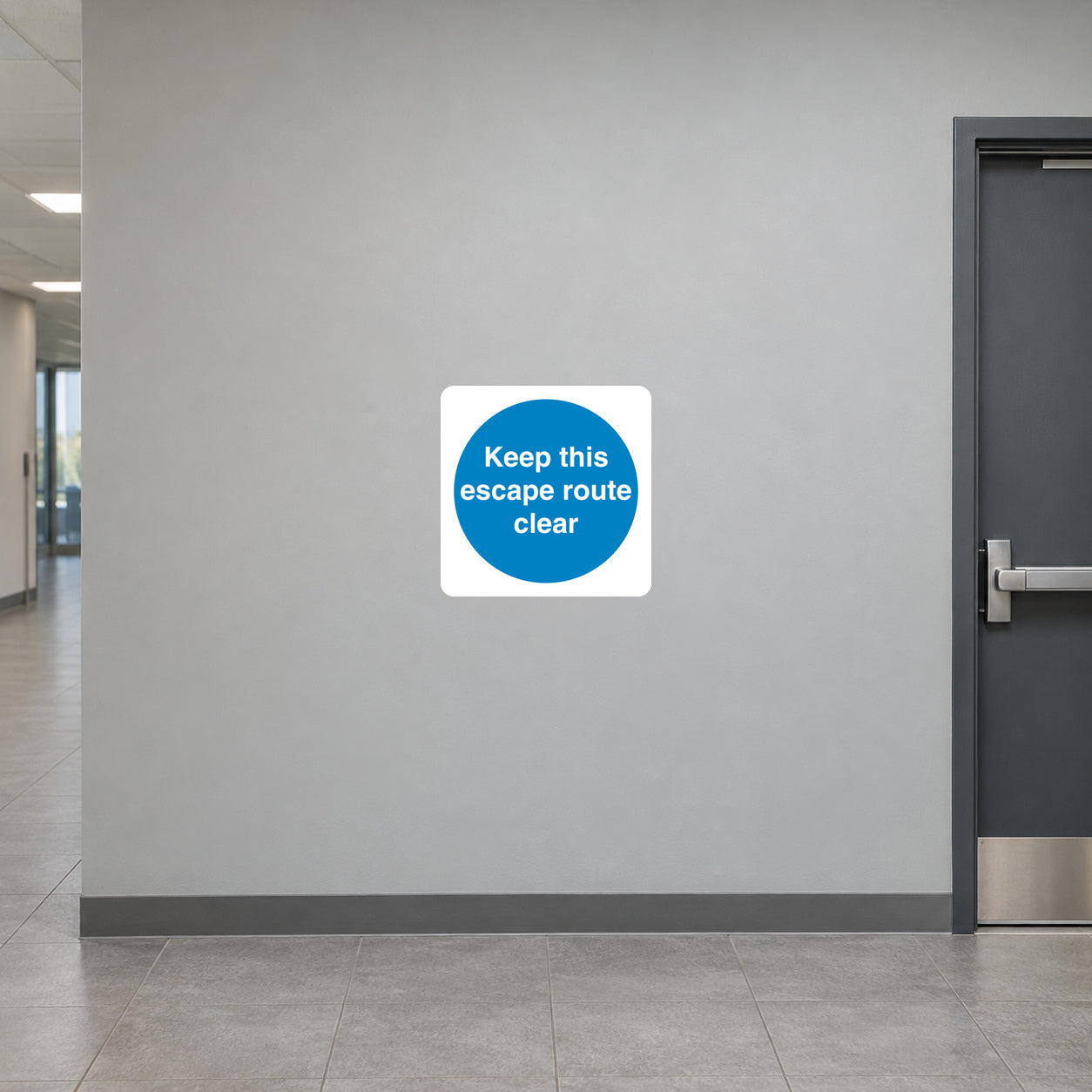 Safety sign sticker: white square with blue circle reading “Keep this escape route clear”