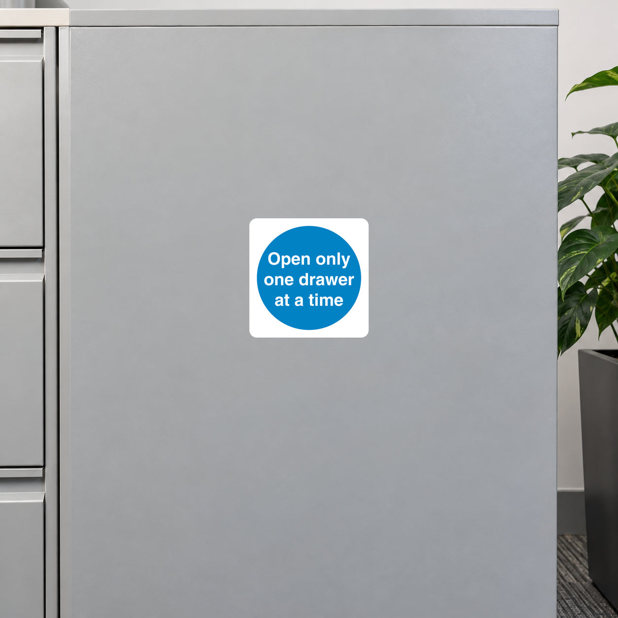 Safety sign sticker: blue circle with 'Open only one drawer at a time' text.