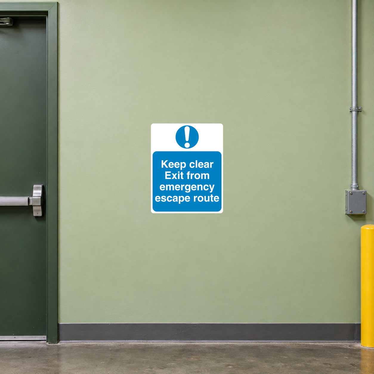 Safety Sign Sticker applied in a smooth pale green wall by a rear workshop emergency escape door, clear route below and door frame extreme left