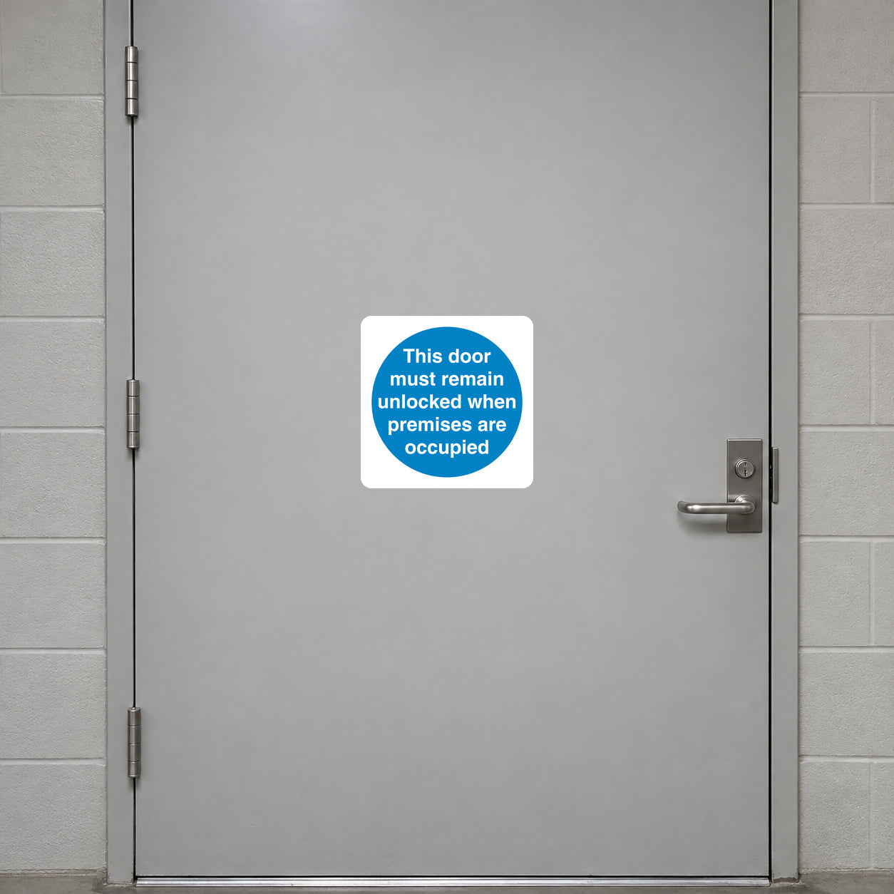 Safety sign sticker with blue text: door must remain unlocked when premises are occupied
