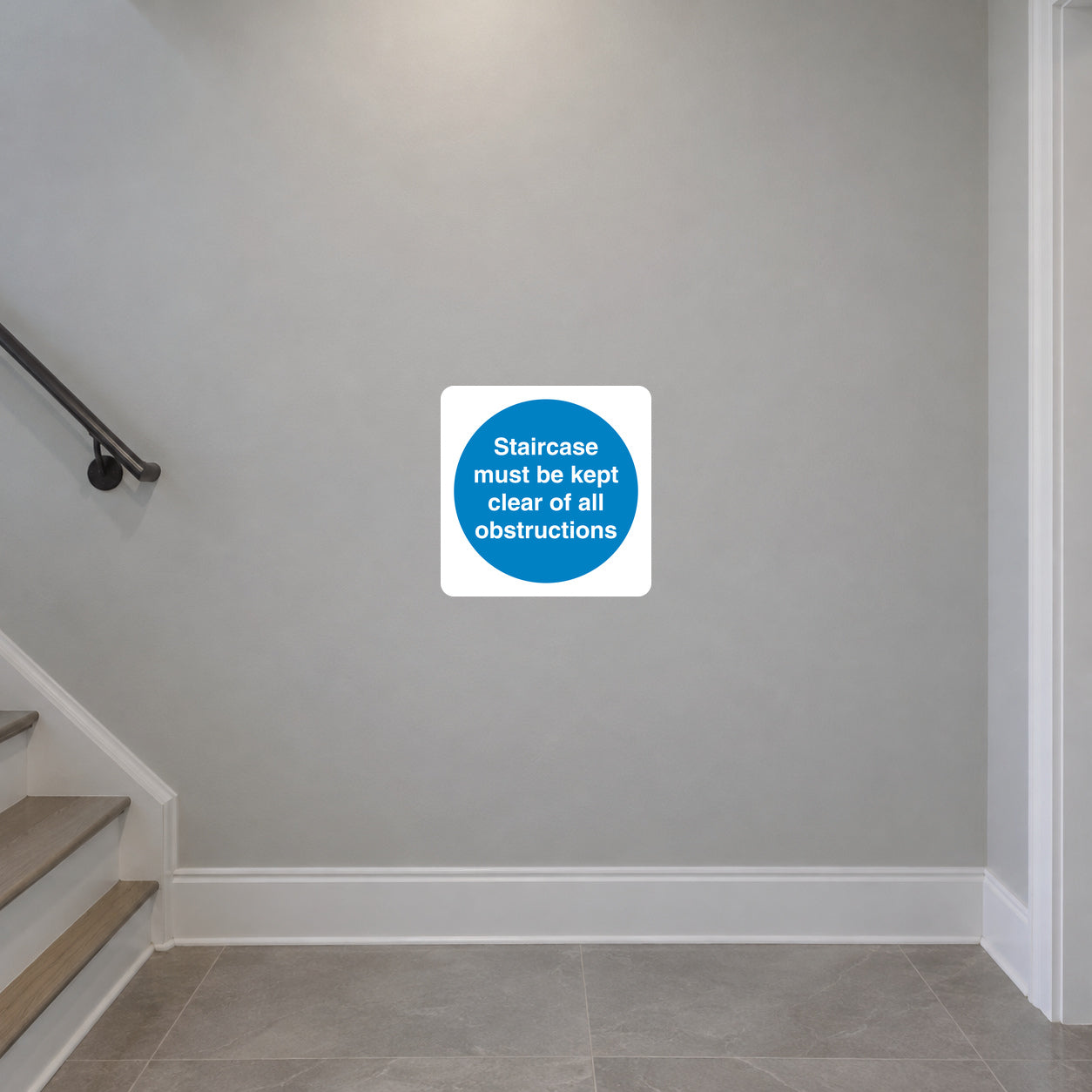 Safety sign sticker with blue circular text: Staircase must be kept clear of all obstructions