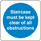 Safety sign sticker with blue circle and white text: Staircase must be kept clear of obstructions