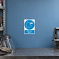 Safety Sign Sticker applied in a smooth muted blue wall at a metal grinding PPE station, face shield resting bottom left and grinder cropped far right