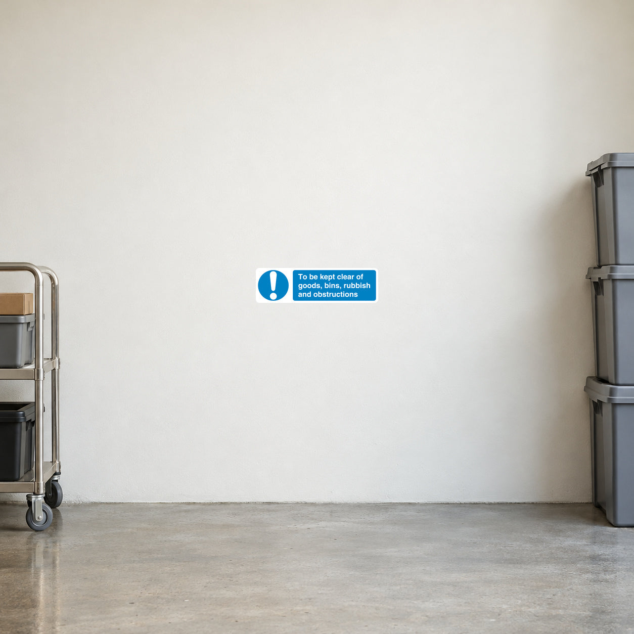 Safety Sign Sticker applied in Pale ivory smooth loading area wall with a clear swept concrete floor, stacked empty bins only at extreme right and goods trolley at extreme left