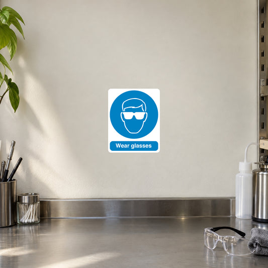 Safety sign sticker with blue circle goggles icon and text Wear glasses