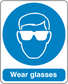 Safety sign sticker: blue circle with face wearing glasses, text 'Wear glasses'.