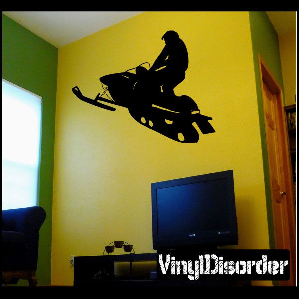 Black snowmobile silhouette decal with rider, applied on a light wall.