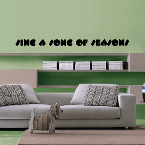 Wall decal reading "SING A SONG OF SEASONS" in black stylized lettering
