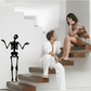 Black skeleton shrugging decal with arms raised on a light wall