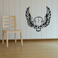 Black vinyl skull wall decal with winged design, centered on a light wall.