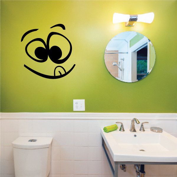 Smiley face toilet decal with black cartoon face design on wall