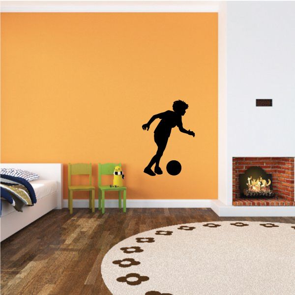 Soccer wall decal featuring a black silhouette player kicking a soccer ball