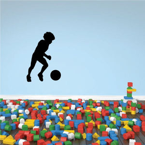 Soccer wall decal of a player kicking a ball, vinyl silhouette.