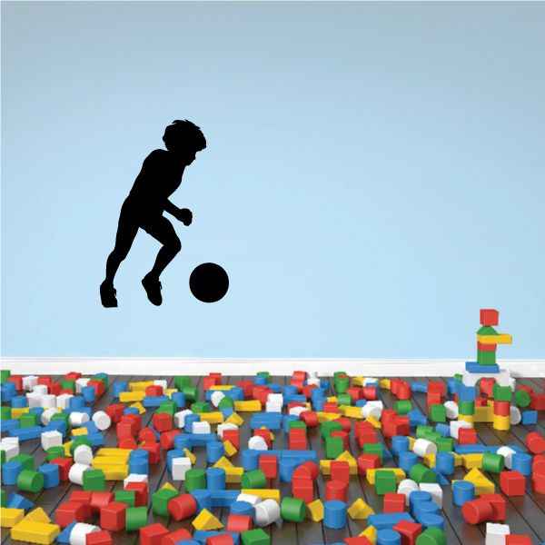 Soccer wall decal of a player kicking a ball, vinyl silhouette.