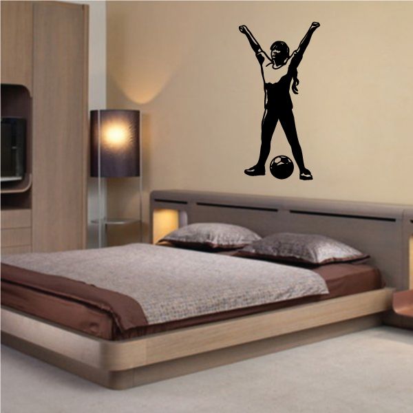Soccer player wall decal in black vinyl, arms raised over a ball