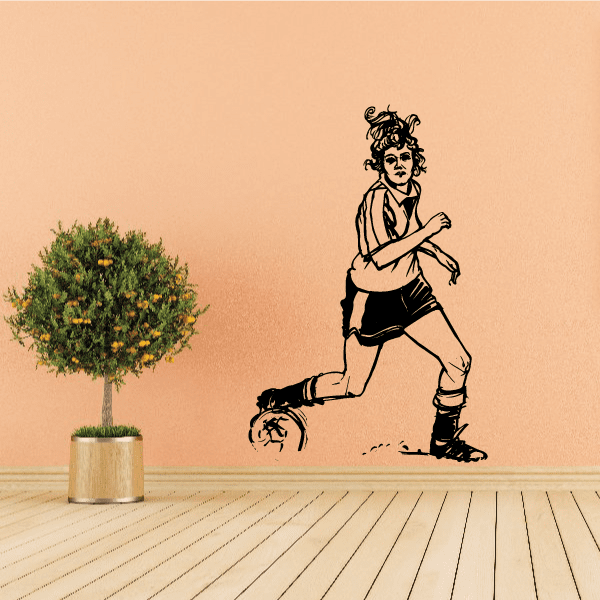 Soccer player wall decal of a woman kicking a ball, vinyl sticker