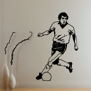 Soccer wall decal of a football player dribbling a ball, black silhouette