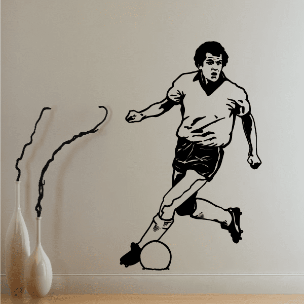Soccer wall decal of a football player dribbling a ball, black silhouette