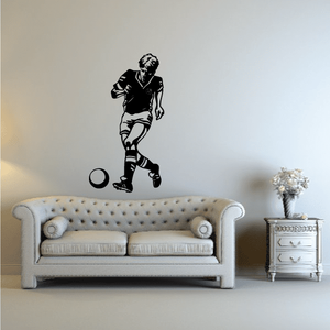 Soccer wall decal of a black soccer player kicking a ball with circular outline