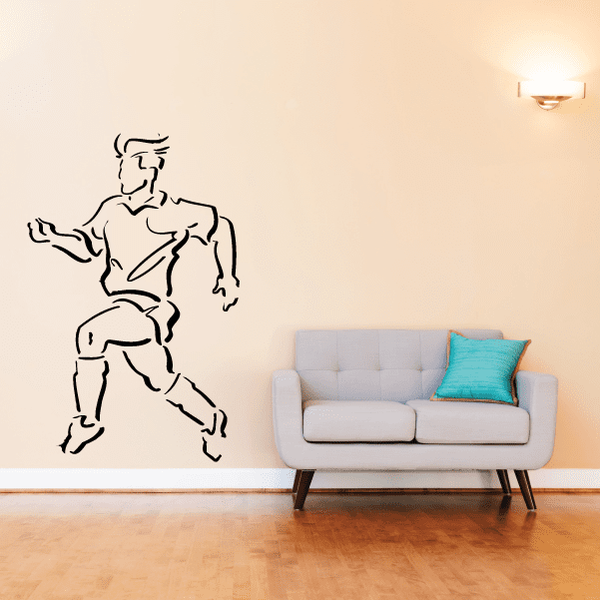 Soccer wall vinyl decal of black-outlined soccer player kicking ball