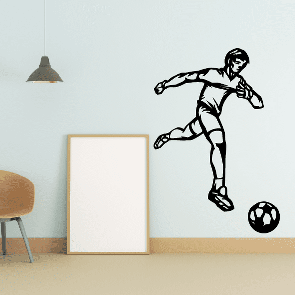 Soccer wall decal of black soccer player kicking ball with soccer ball outline