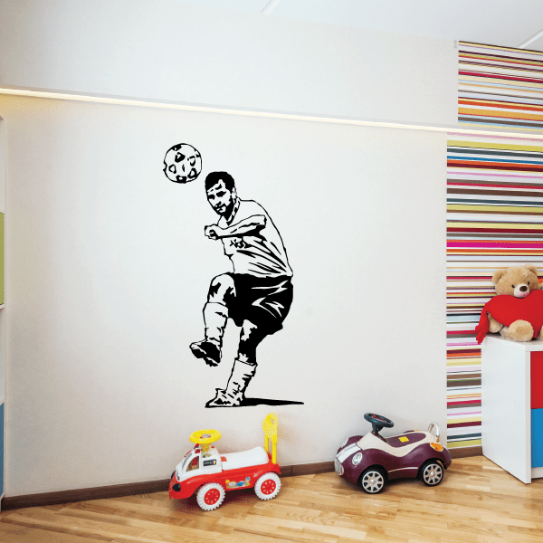 Soccer wall vinyl decal of a black soccer player kicking a ball on a white wall