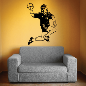Soccer wall decal of a player kicking a ball in black and yellow vinyl silhouette