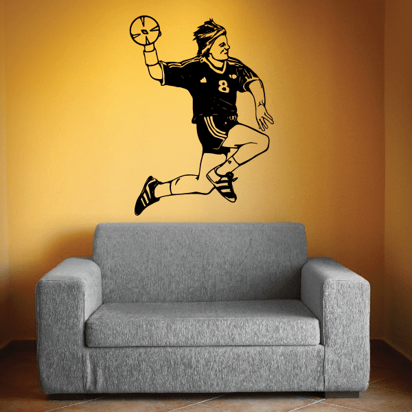 Soccer wall decal of a player kicking a ball in black and yellow vinyl silhouette
