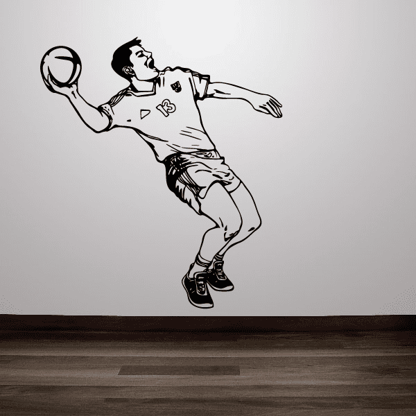Soccer player wall decal, black vinyl style figure holding ball in shooting pose.