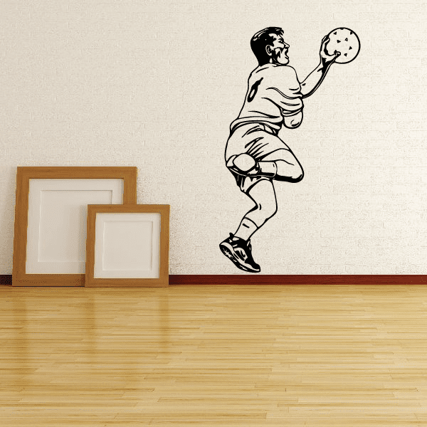 Soccer wall vinyl decal of a kicking player holding a ball