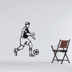 Soccer player vinyl wall decal in black, kicking a soccer ball