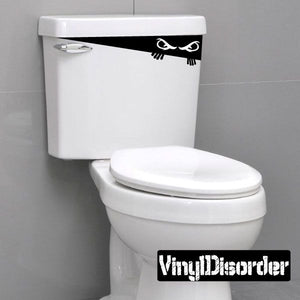 Black cartoon toilet monster decal with eyes and tentacles on the tank lid