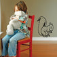 Squirrel eating decal, black outline of a squirrel holding food on wall