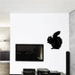 Squirrel munching decal, black silhouette on light wall.